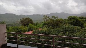 a balcony of a house with a view of the mountains at Machan Studio Villa in Karandi Khurd
