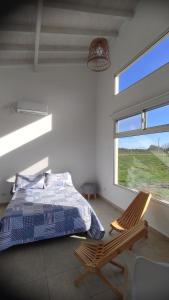 Un dormitorio con una cama y una silla y una ventana. en Alamos David, en Villaguay