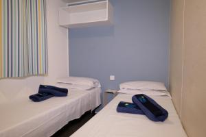 Postel nebo postele na pokoji v ubytování Happy Camp Mobile Homes in Camping Iscrixedda