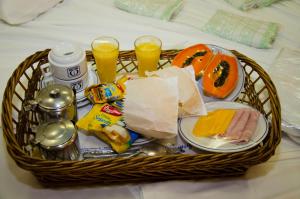 a basket filled with food and drinks on a bed at Omega Palace Hotel in Sao Paulo