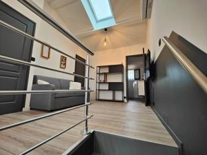 una camera con una scala con un divano e una finestra di Maison classé 3 étoiles Pérols avec terrasse et clim a Pérols Altre 6 foto