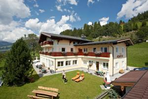 - une vue aérienne sur une maison avec des personnes dans la cour dans l'établissement Alpenhof Apartments, à Mittersill
