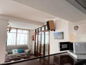 a living room with a couch and a microwave at Hostal Horizonte in San Antonio