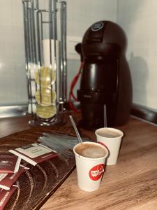 two cups of coffee on a counter with a coffee maker at Poga Apartment in Durrës