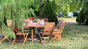 Una mesa de madera con cuatro sillas alrededor. en La Chambre des Châteaux, en Cellettes