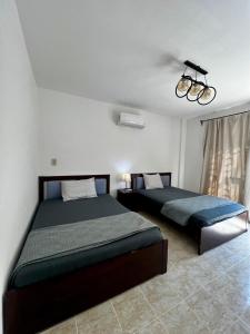 ein Schlafzimmer mit zwei Betten und einem Kronleuchter in der Unterkunft Diamond Madinaty New Cairo in Madinaty