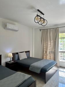 1 Schlafzimmer mit 2 Betten und einer Leuchte in der Unterkunft Diamond Madinaty New Cairo in Madinaty