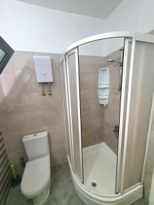a bathroom with a shower and a white toilet at kaymaklı suna apartmanı in Omorphita