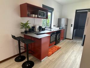 a small kitchen with a stove and a microwave at Studio avec piscine in Cayenne