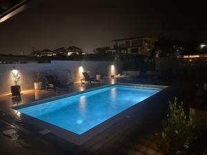 a blue swimming pool at night with a patio at Studio avec piscine in Cayenne
