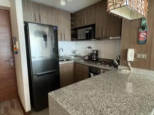 a kitchen with a black refrigerator and a counter at Apartamento Centro de Concepcion in Concepción