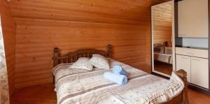 a bed in a wooden room with towels on it at Vodoliy in Mykulychyn +64 photos