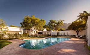 a swimming pool in the yard of a house at Leeu House in Franschhoek