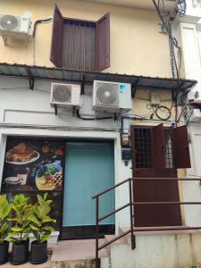 a building with a door and a window with plants at CJ Cozy House 5 Mins Walk to Jonker Street in Melaka +11 photos