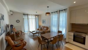 a kitchen and living room with a table and chairs at BW Arcadia deluxe apartments in Sajmište