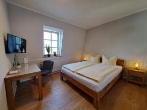 LuckaHotel zum Hirsch的一间卧室，里面有一张床、一张桌子和一台电视。