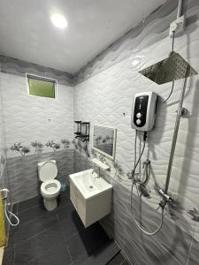 a bathroom with a toilet and a sink at Homestay Pusat Bandar Kangar in Kangar