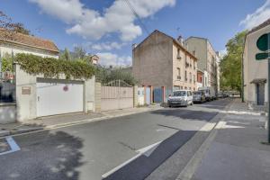 una calle con coches aparcados al costado de la carretera en Studio chic aux portes de Paris, en Colombes
