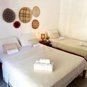 two beds in a room with towels on them at POUSADA VILLA SOLEIL icaraizinho in Icaraí