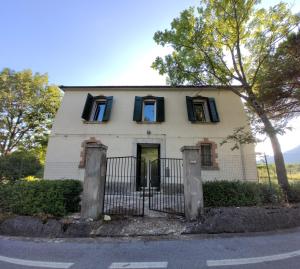 a white house with black windows and a gate at La Casa del Conte in Cerreto
