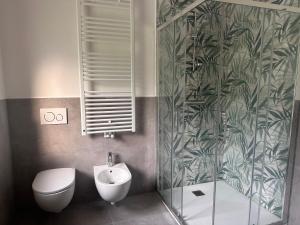 a bathroom with a toilet and a sink and a shower at Appartamenti Ai 7 nani in Peron