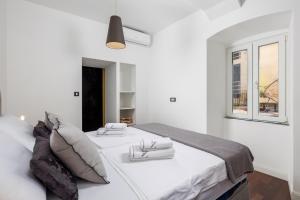 Un dormitorio blanco con dos camas y una ventana. en Apartment J'adore by Rent Istria, en Rijeka