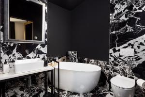 Un baño en blanco y negro con bañera e inodoro. en Apartment J'adore by Rent Istria, en Rijeka