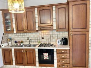 a kitchen with wooden cabinets and a stove top oven at Mussomeli's Beautiful House in Mussomeli