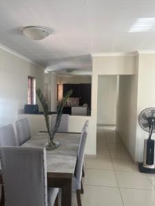 a dining room and living room with a table and chairs at Centurion Family House in Centurion