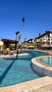 una piscina in un resort con palme e edifici di Taiba Beach Resort a Taíba
