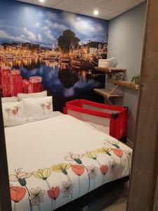 a bedroom with a bed with a painting of a harbor at Appartement De Oliekan Medium in Lemmer