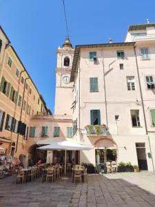 a building with a clock tower and tables and chairs at La Maddalena Apartment in Bordighera
