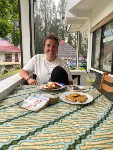 不拉士打宜Sibayak Multinational Rest House的坐在餐桌上吃盘子的人