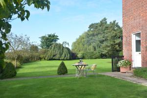 a table and chairs in a yard with a green lawn at Rookyards in Spexhall
