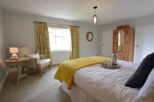 a bedroom with a bed and a chair and a window at Rookyards in Spexhall