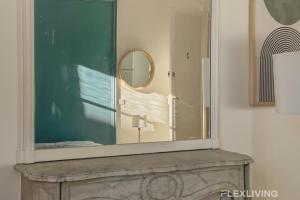 ein Spiegel auf einem Kamin in der Unterkunft Flexliving - room - Felix Faure in Paris
