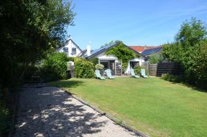 una casa con un cortile con delle sedie di B&B Onder de Molen a Burgh Haamstede