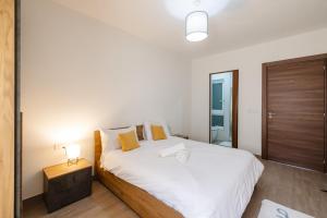 Un dormitorio con una gran cama blanca y un espejo. en Cosy Retreat, en Naxxar
