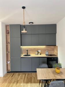 a kitchen with black cabinets and a wooden table at Montenegro Suite Rental in Bar +14 photos