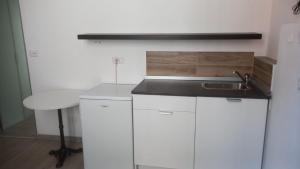 a kitchen with white cabinets and a sink and a stool at Casa di Leo e Vale in Imola
