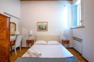 a bedroom with a bed and a desk and a window at Residenze Giulietta Capuleti 1 in Verona