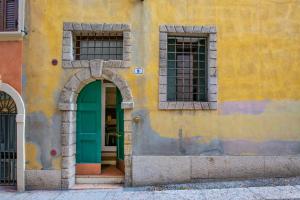 a building with a green door and two windows at Residenze Giulietta Capuleti 1 in Verona
