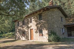 an old stone building with a brown door at Abissinia, Gioiello nel Bosco in Poiano