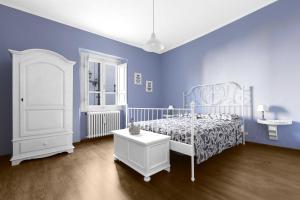 a blue bedroom with a white bed and a blue wall at Da Vinci Sweet Home in Castiglion Fibocchi