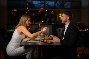 a man and a woman sitting at a table eating food at Hotel A'mare in Zadar