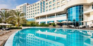 una piscina di fronte a un hotel di Crowne Plaza Muscat OCEC by IHG a Mascate