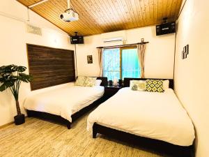 a room with two beds in a room at Lodge Crea in Ujimi