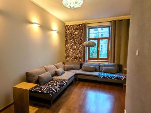 een woonkamer met een bank en een raam bij Midcentury modern, quiet, 40m studio with bath in Rīga