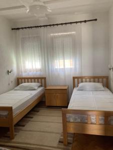 two beds in a room with two windows at Trpejca Holiday Home in Trpejca