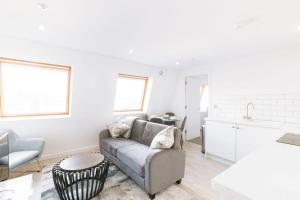 イプスウィッチにあるBudget 1 Bed Top Floor Apartment in Ipswichのソファとテーブルのある白いリビングルーム +15枚の写真